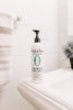 Bottle of Original Sprout Scrumptious Baby Cream on a white surface with a blurred background
